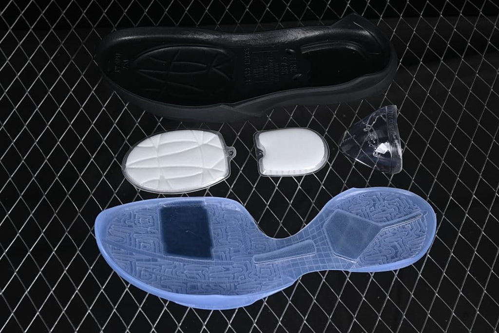 Outsole and detached shoe components shown beside a pale blue basketball shoe sole