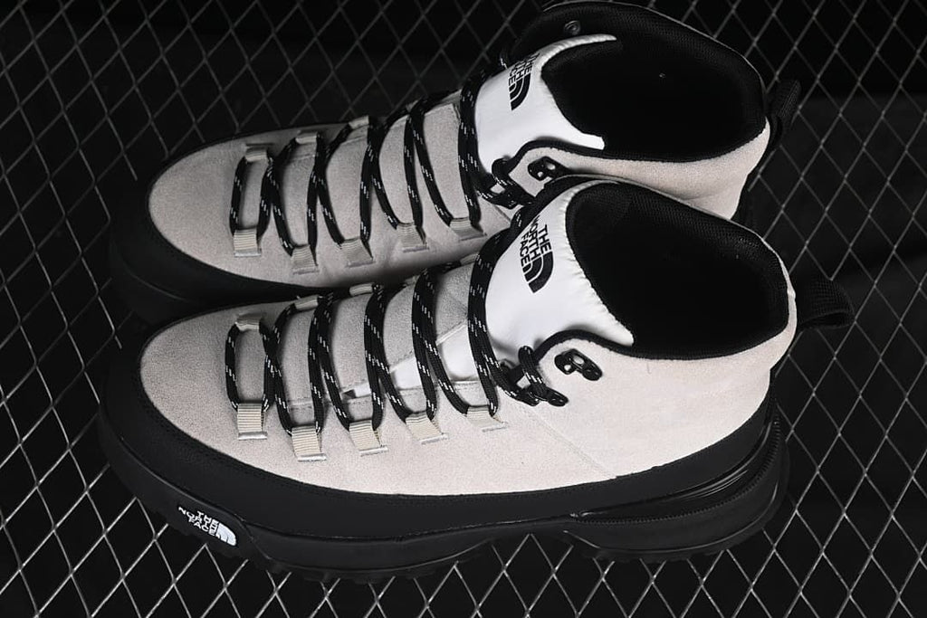 Pair of light and black mid-height boots viewed from above
