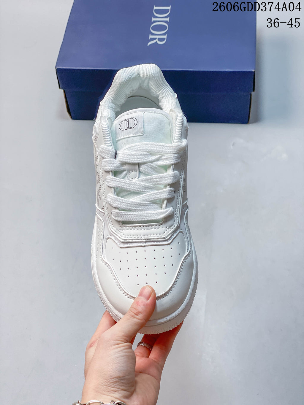 Top-down view of a white lace-up sneaker with a perforated toe and tongue logo.