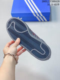 Outsole of a dark adidas Originals Superstar 2 sneaker held above a blue shoe box