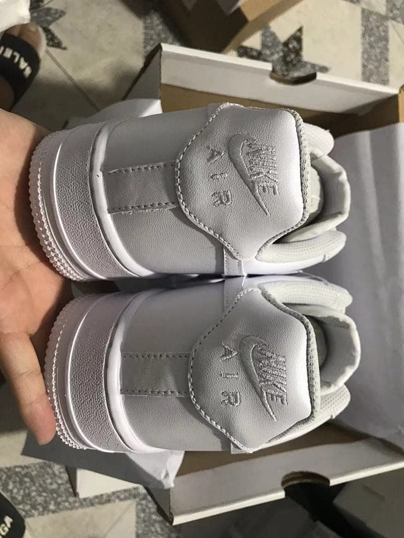 Rear view of the white sneakers showing the heel tabs and stitching.