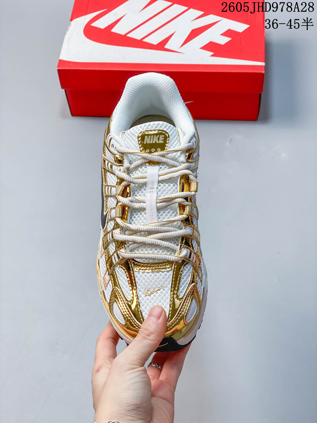 Top view of the white and gold-tone Nike Initiator with laces and mesh-look panels