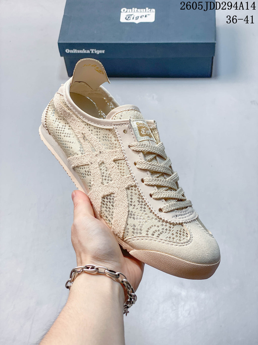 Angled view of a cream Onitsuka Tiger low-top sneaker with patterned textile panels