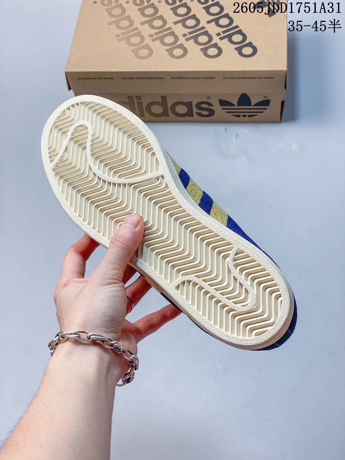 Underside view showing the cream-colored patterned outsole of a blue sneaker