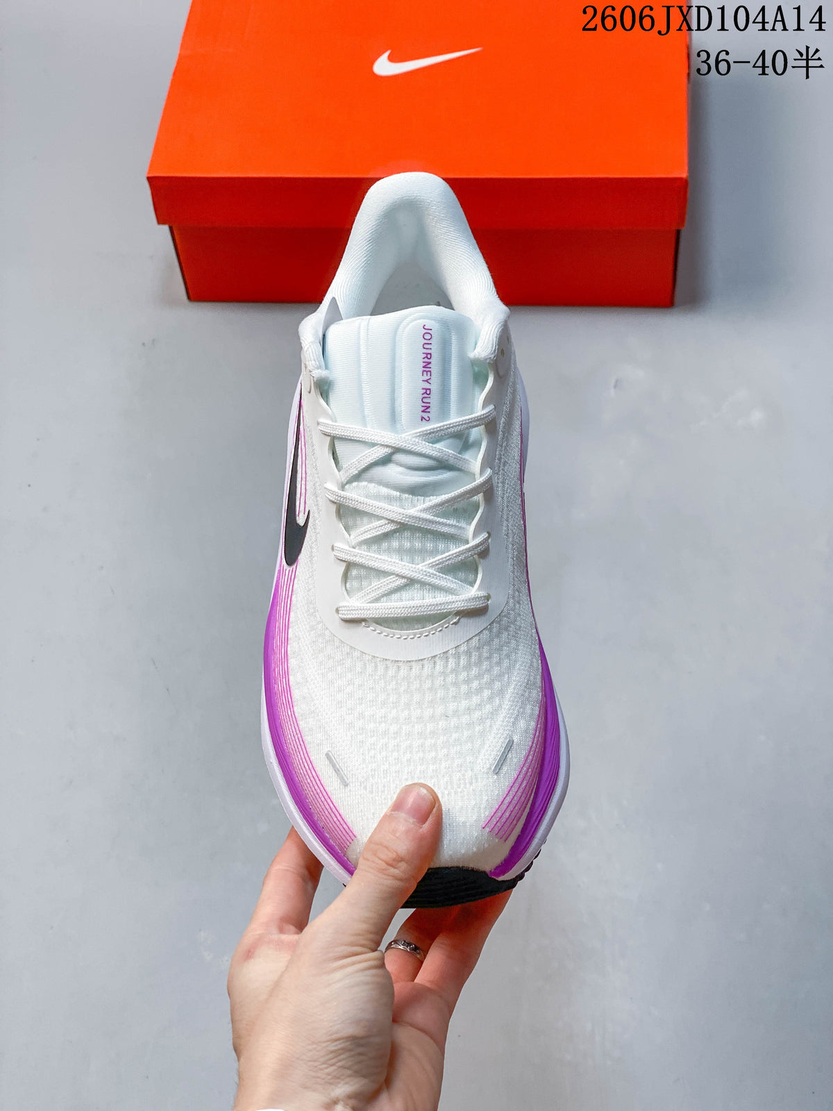 Front view of the lace-up white running shoe with purple accents.