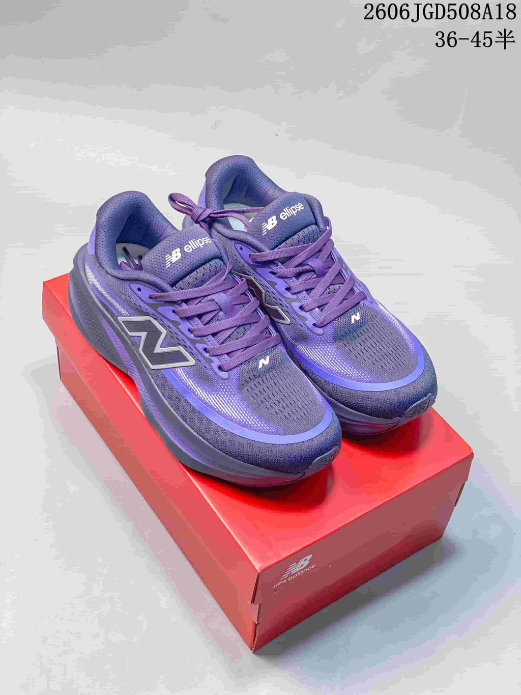 Purple New Balance running shoes displayed on a red shoebox
