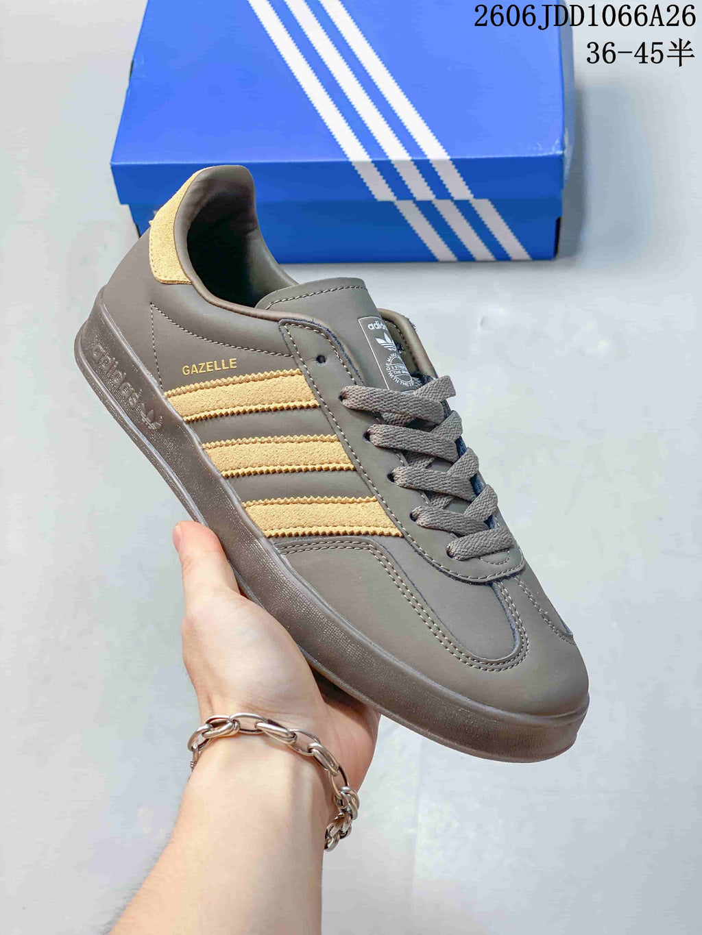 Angled side view of the grey sneaker with gold-tone stripes and heel detail