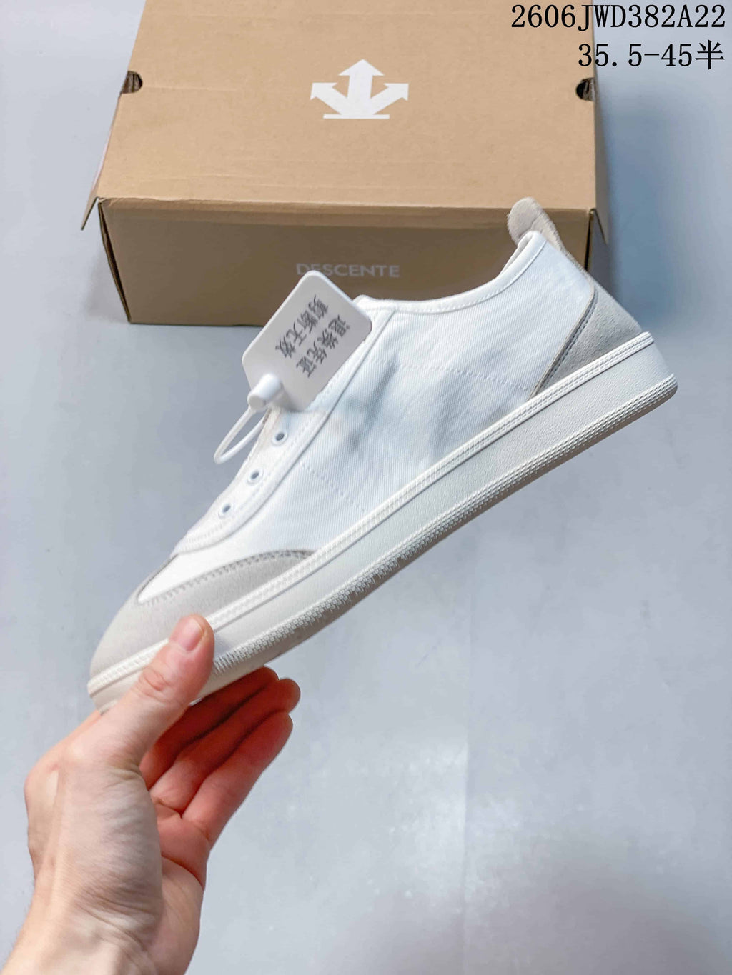 Side profile of the white sneaker with light grey overlays and a low-profile sole