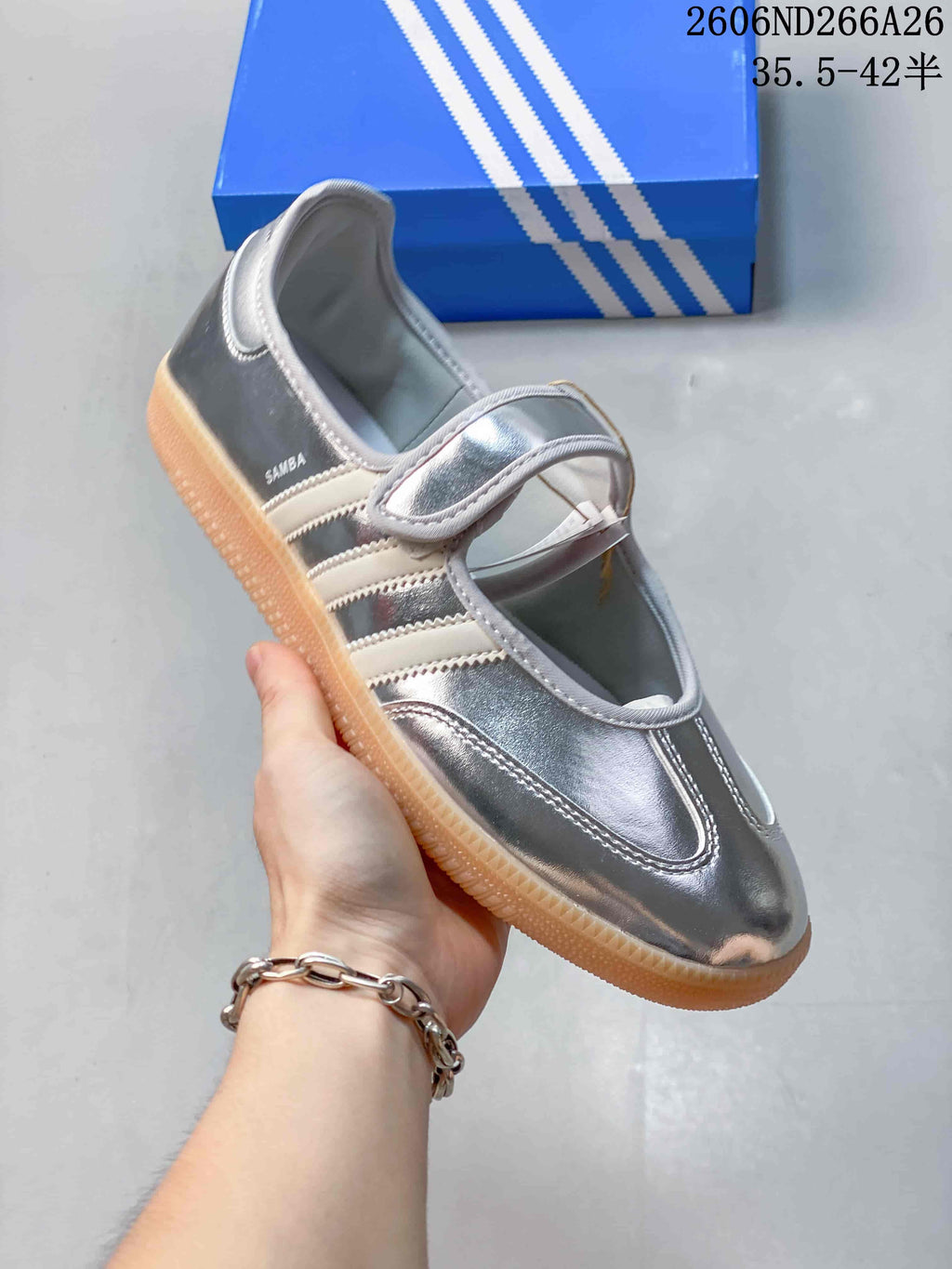 Angled view showing the silver upper, Mary Jane strap, side stripes, and Samba side branding.