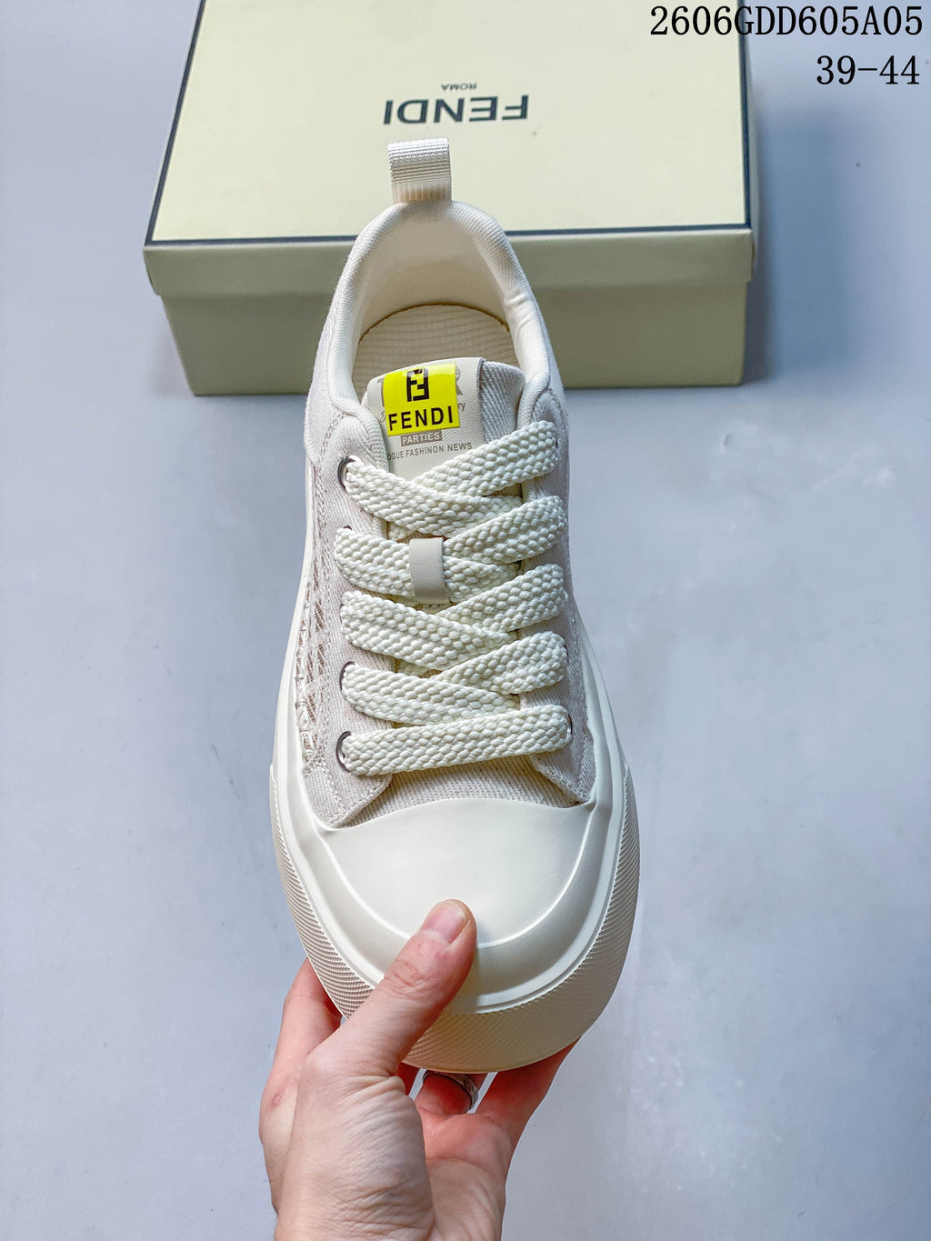 Top view of a cream sneaker showing wide laces and a smooth toe overlay