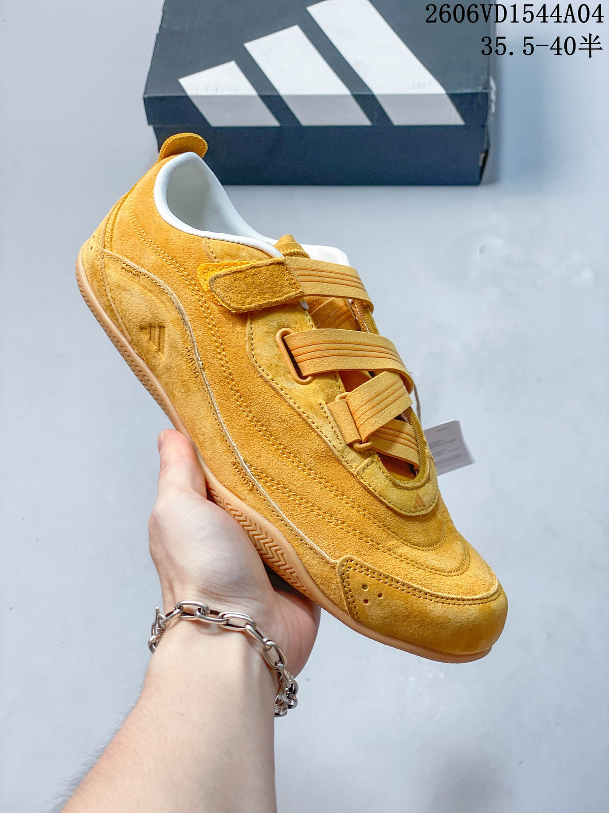 Angled side view of a golden yellow low-top sneaker with layered panels and a gum-tone outsole.