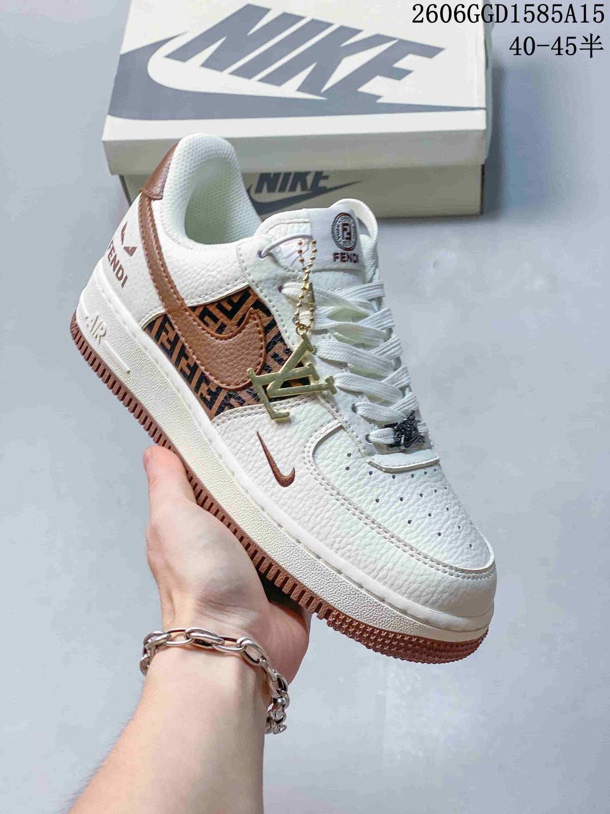Close-up of a white low-top sneaker with brown patterned side panels, brown swoosh detail, and a decorative lace charm.