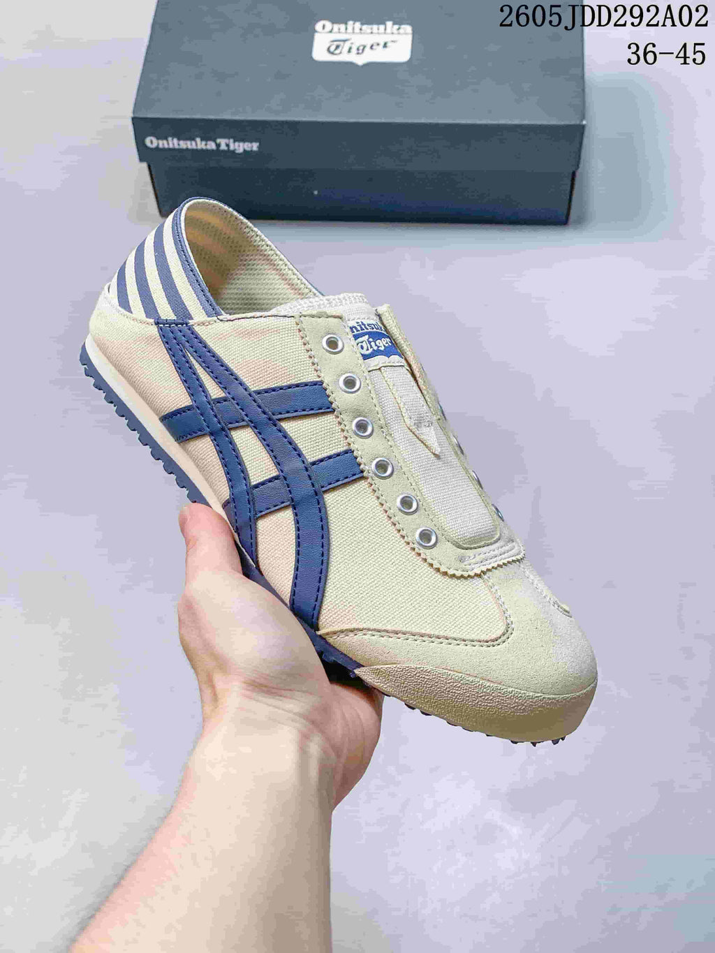 Light-colored slip-on sneaker with dark blue side stripes and a striped heel panel