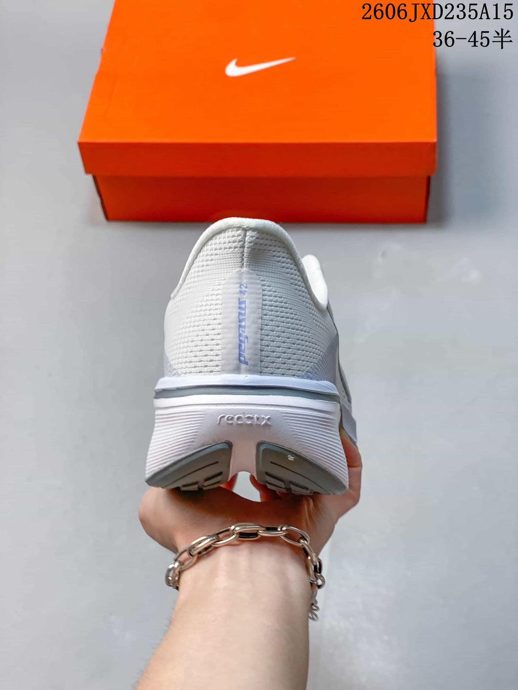 Rear view of the white Nike Pegasus 42 shoe with grey heel details