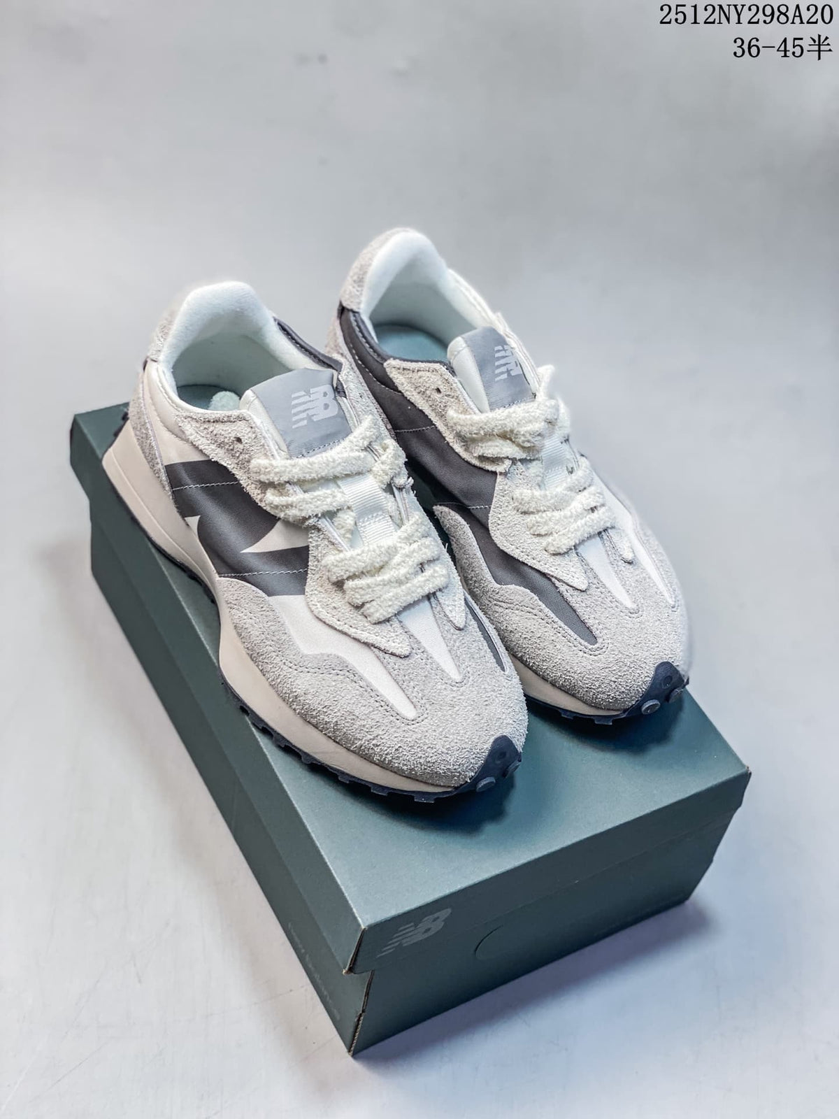 Pair of gray and navy New Balance 327-style sneakers on a shoebox