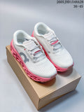 Pair of white On Cloudmonster 3 shoes with gray logos and pink soles, displayed on a box