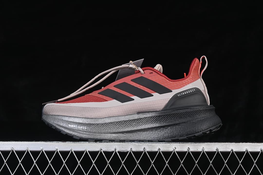 Side view of red and gray adidas Ultraboost 5 running shoe with black stripes