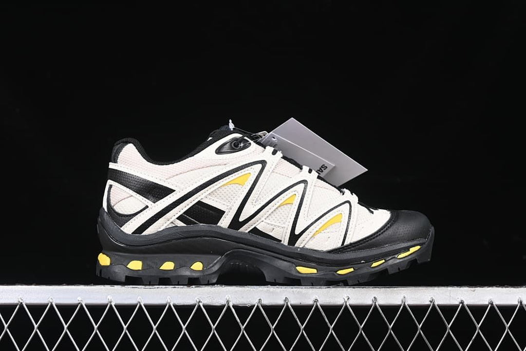 Side profile of one shoe showing its layered panels and yellow accents.