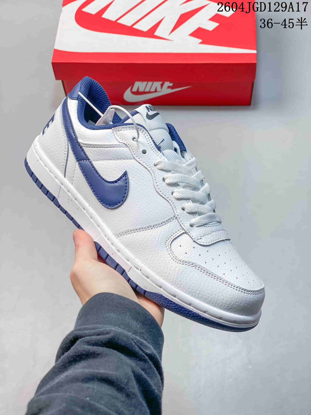 Close-up of a white Nike Big Low sneaker with a blue Swoosh and blue outsole accents.
