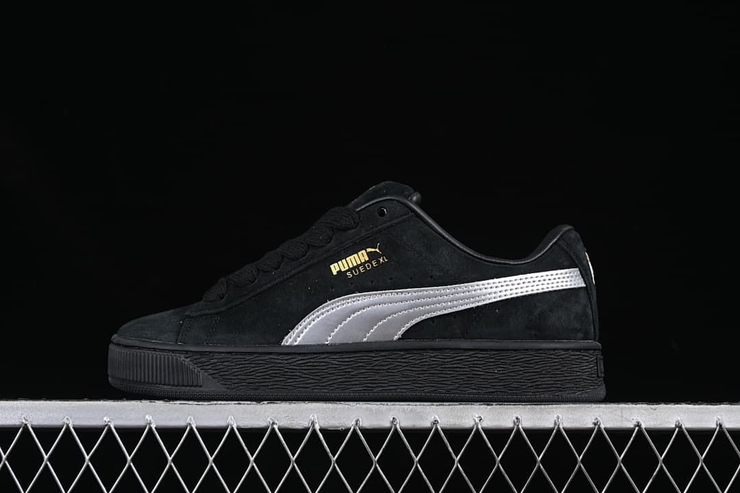 Side view of a black Puma Suede XL sneaker with a silver stripe and black sole.