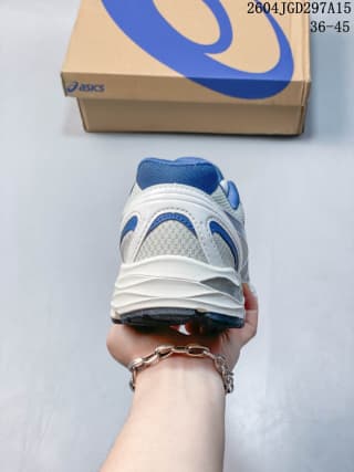Rear view of the white and blue ASICS sneaker beside its branded shoe box, with a size marking visible on the image.