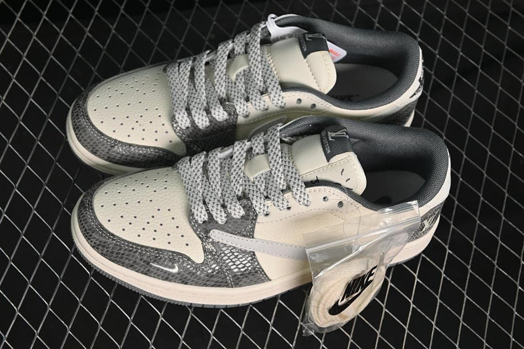 Top view of a pair of cream and gray low-top sneakers with patterned laces and dark overlays.