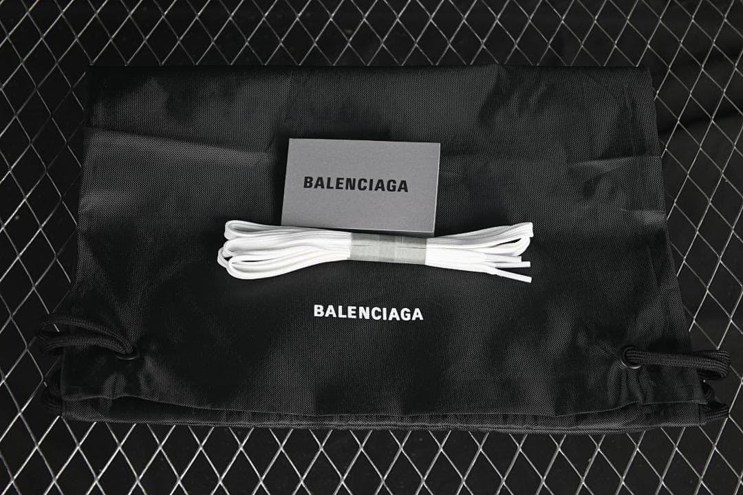 Black drawstring bag, card and spare white laces shown with Balenciaga branding
