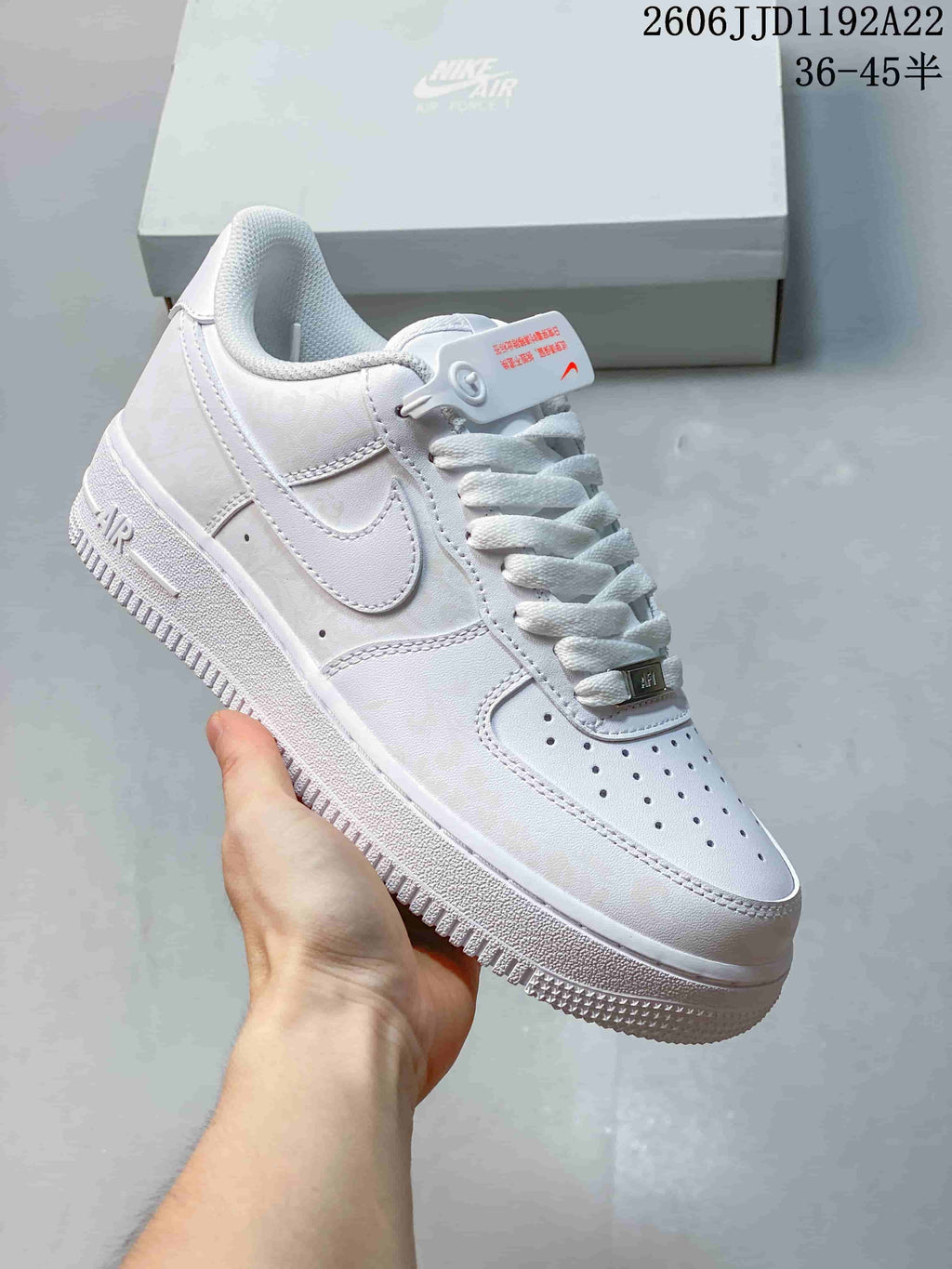 White low-top sneaker with perforated toe and white laces, shown beside a shoe box