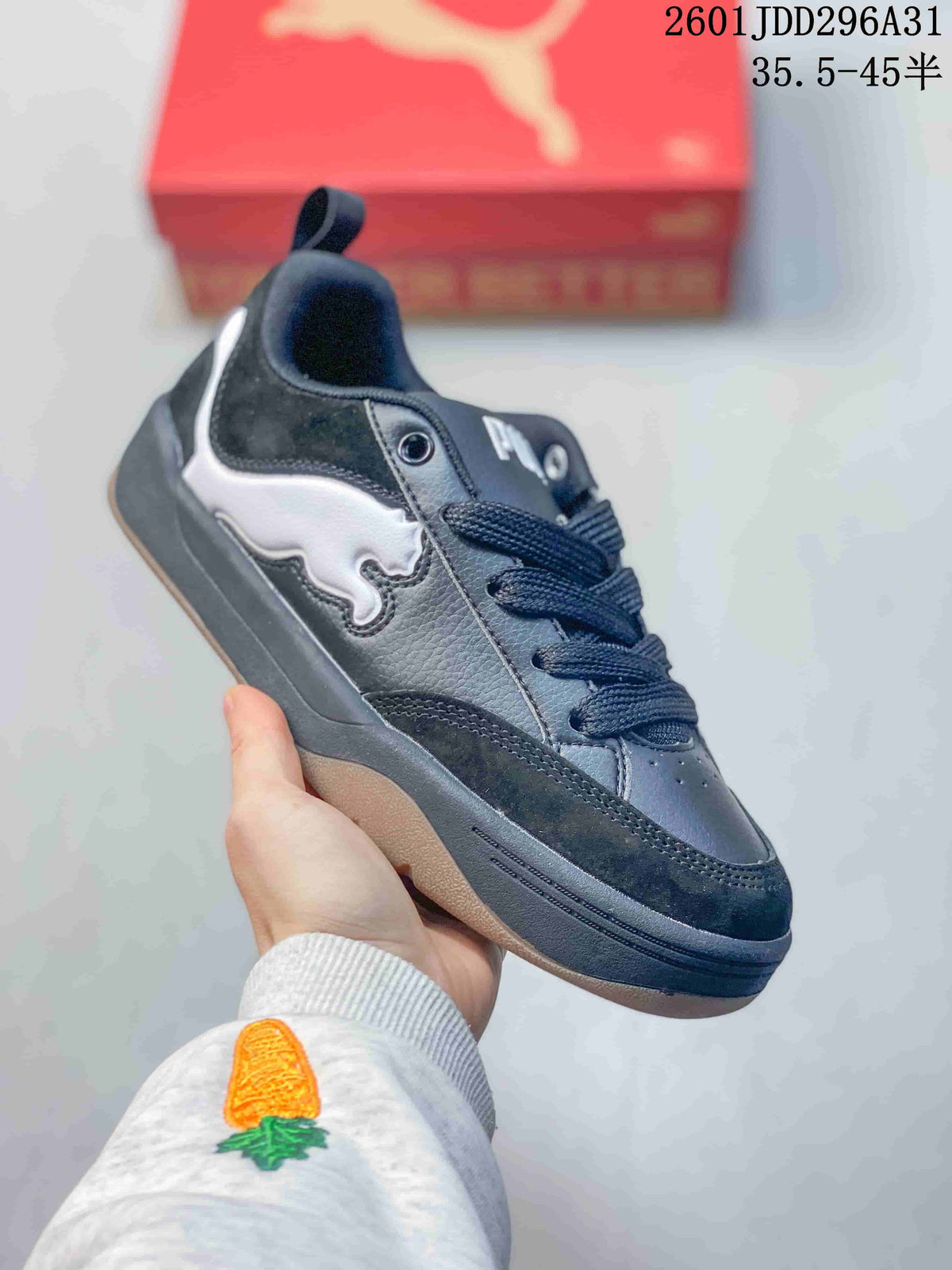 Angled side view of a dark sneaker with white side detail, laces, and a gum-tone outsole