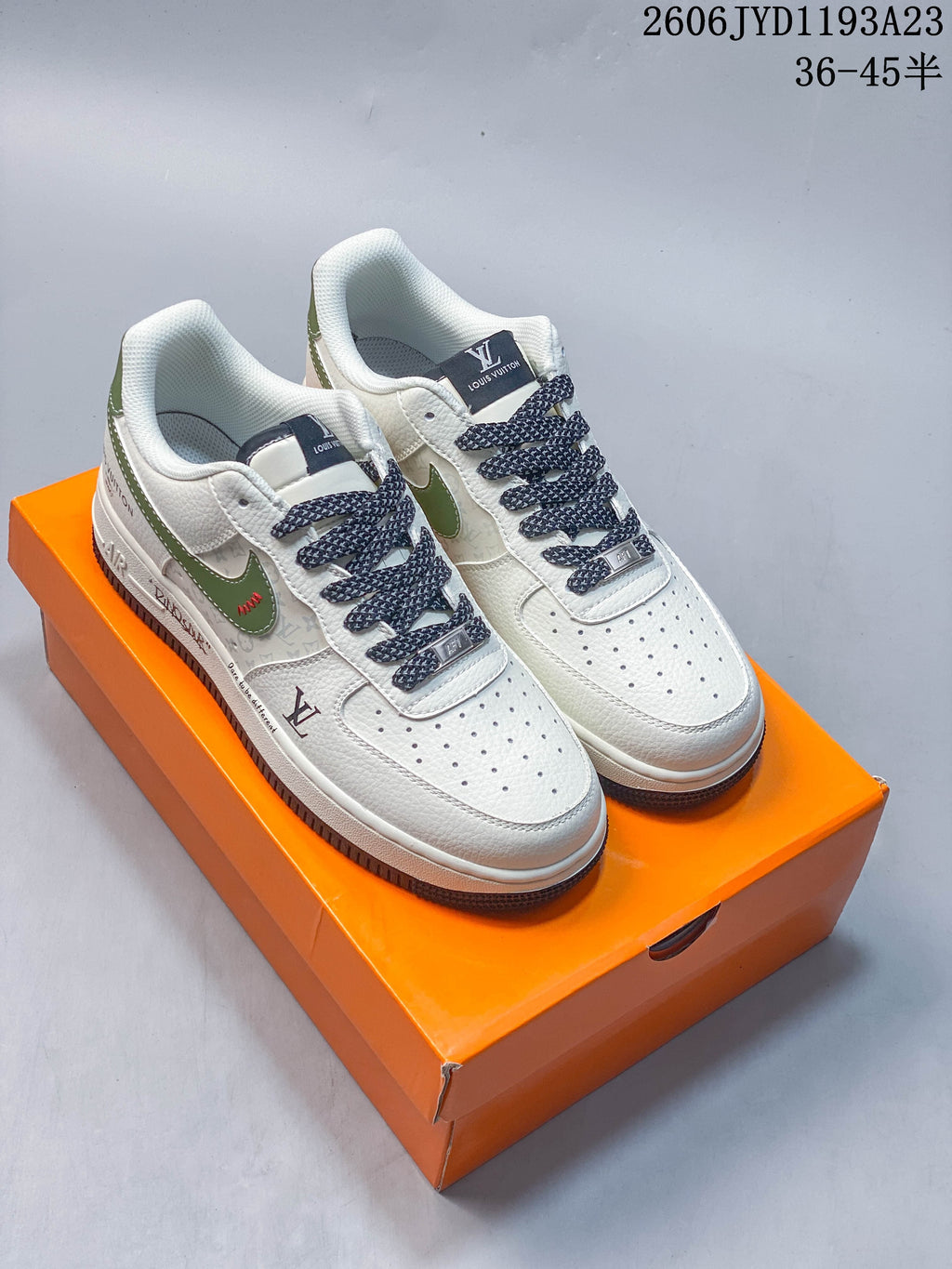 Pair of white low-top sneakers with green accents, patterned side panels, and dark patterned laces.