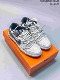 Pair of patterned white and gray low-top sneakers with layered laces on an orange box