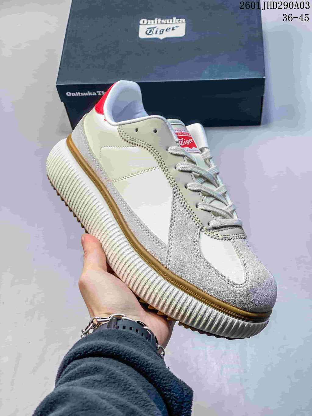 Close side view of the sneaker showing its layered panels, red heel accent, and ribbed sole