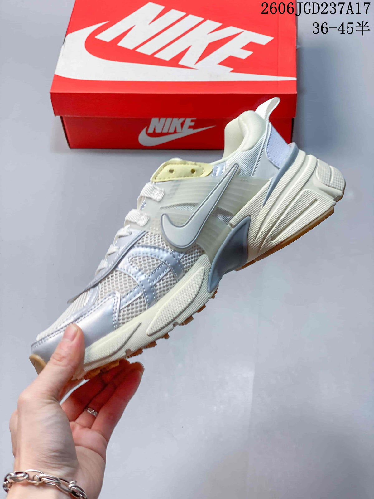 Side view of a white and silver low-top sneaker with mesh panels and layered overlays.