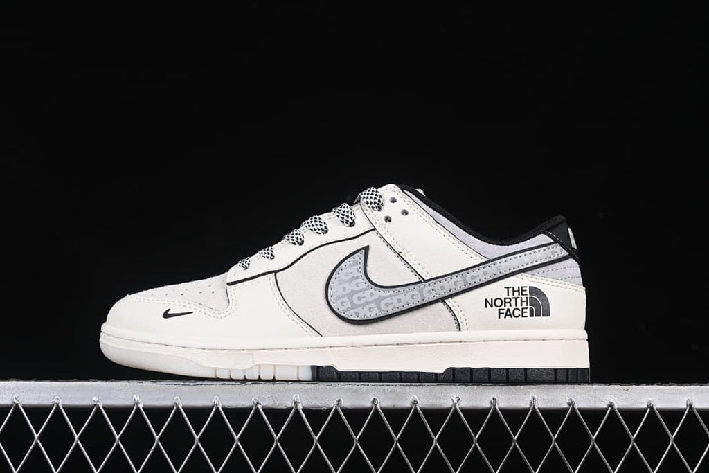 Side profile of the sneaker with grey patterned Swoosh and The North Face branding