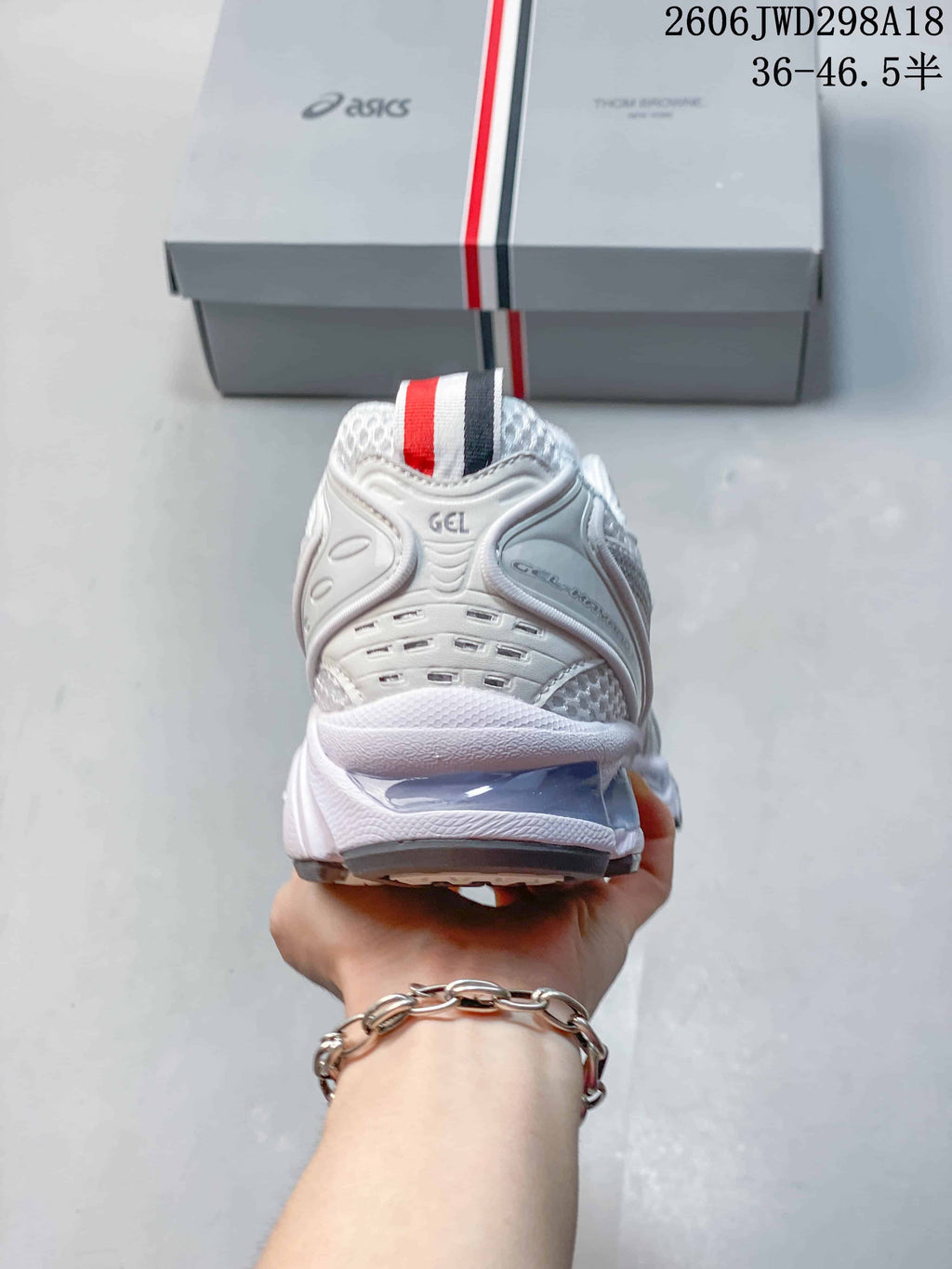 Rear view of the white ASICS GT-2160 sneaker with a striped heel pull tab