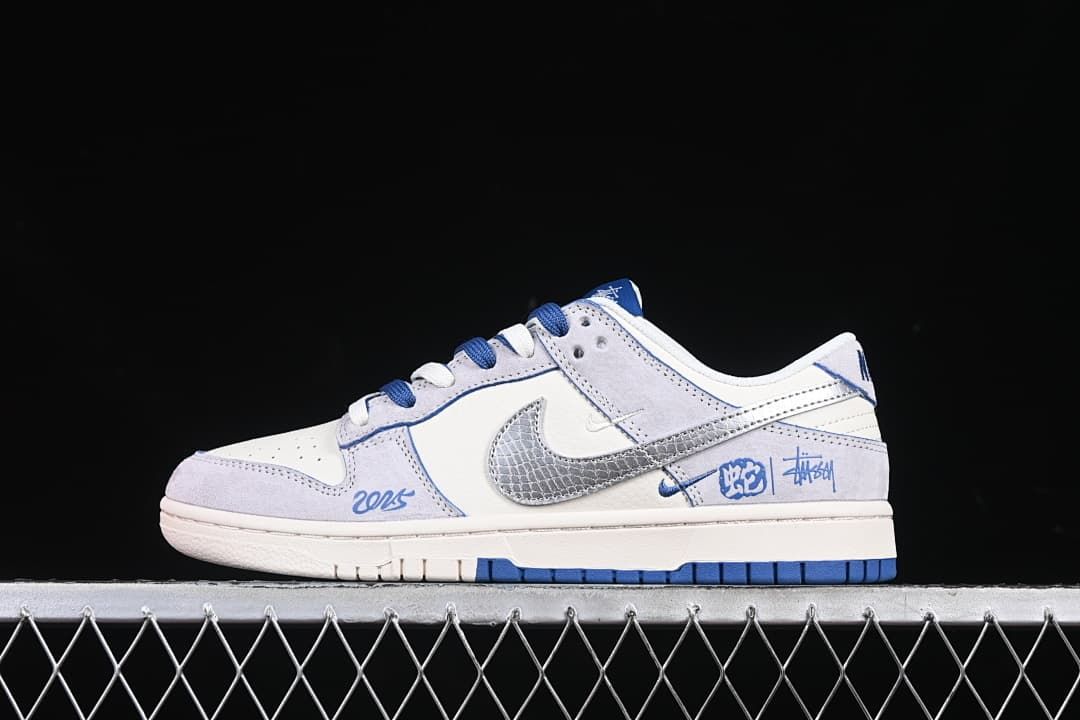 Side view of a white and pale gray low-top sneaker with blue accents and a metallic silver patterned Swoosh