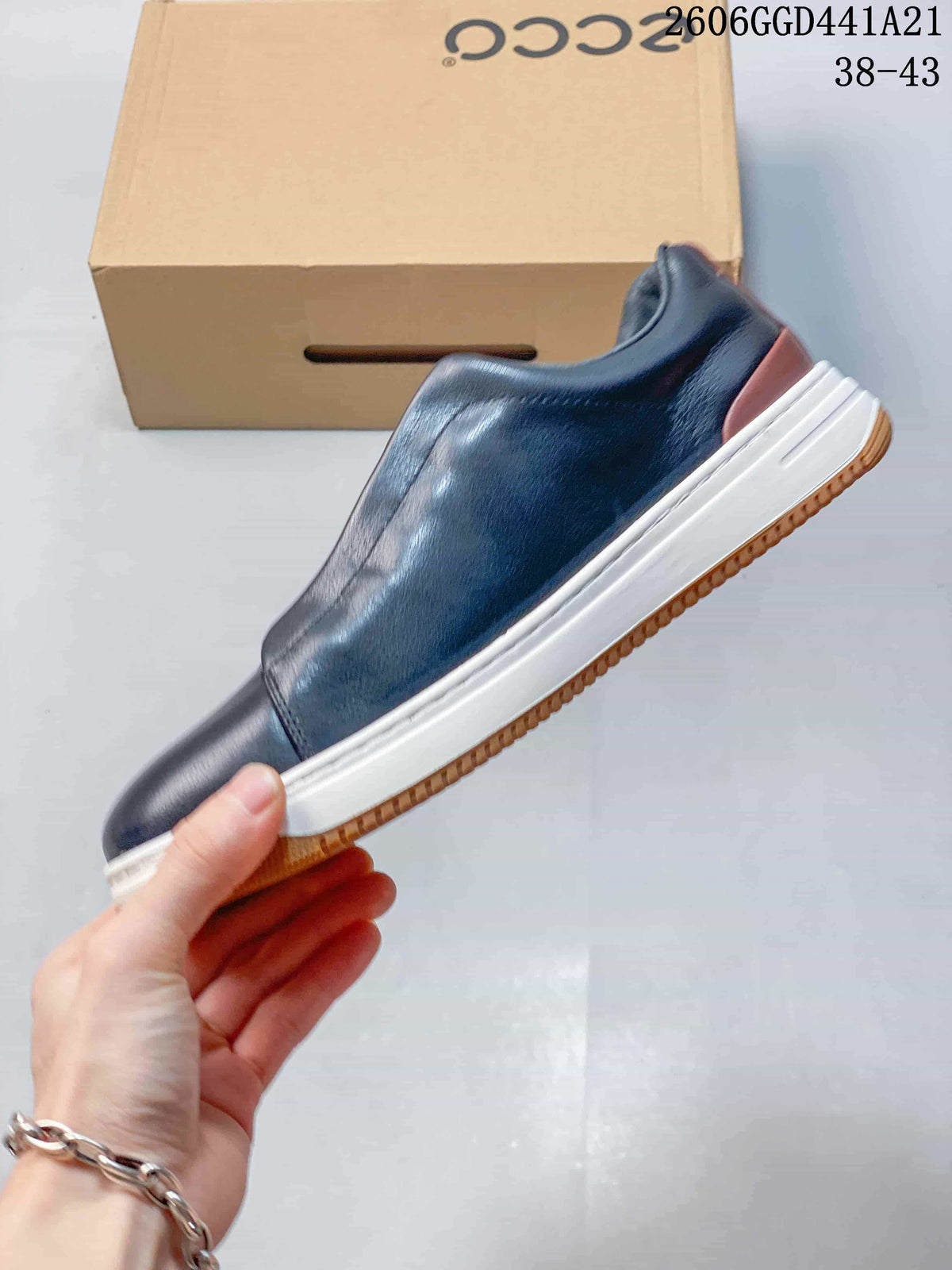 Side view of a navy sneaker with brown heel detailing, a white midsole and a textured brown outsole.
