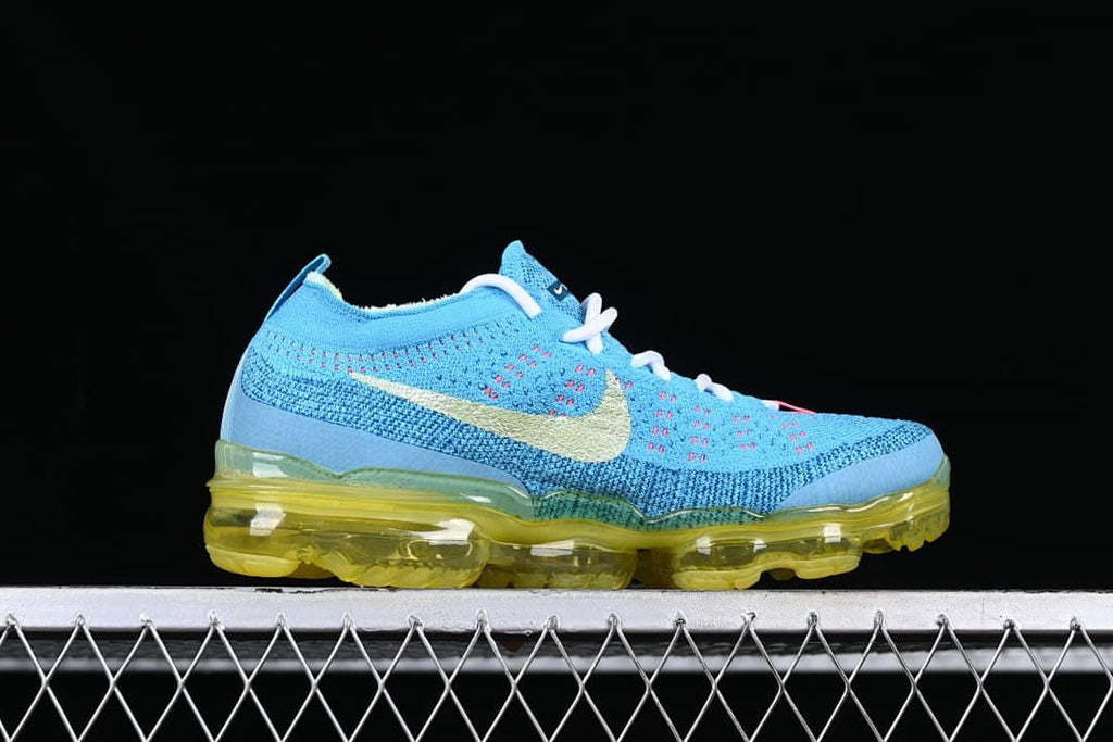 Side profile of the blue knit shoe with a pale Swoosh and translucent yellow sole.