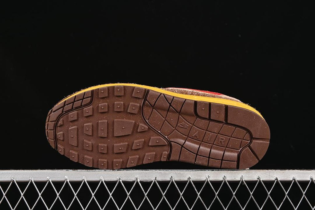 Brown outsole with segmented tread and yellow midsole edge.