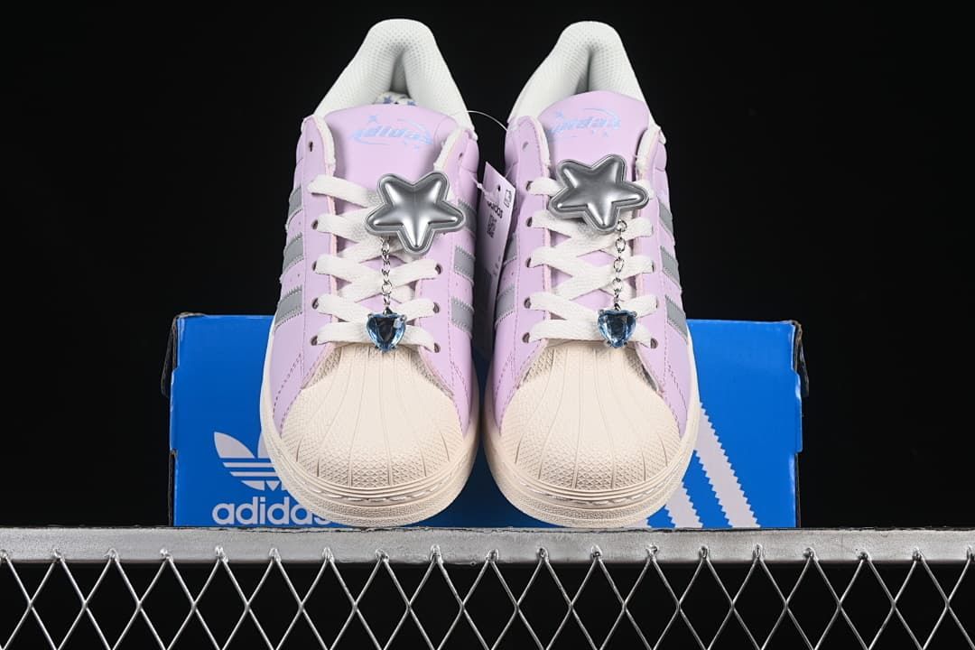 Front view of both sneakers with star charms, displayed on the shoebox