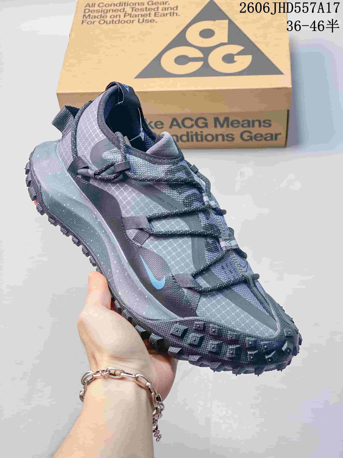 Nike ACG Mountain Fly sneaker in gray and blue with patterned panels and a lugged outsole.