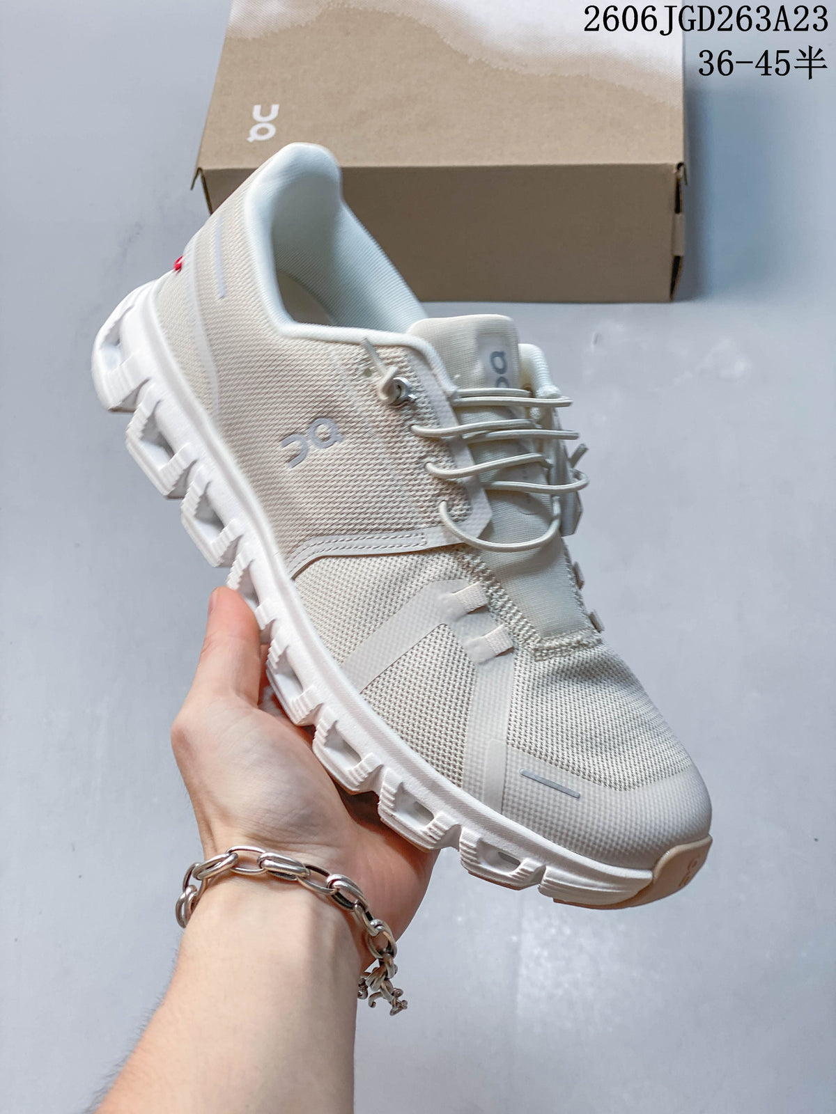 Angled side view of a light ivory On Cloudtilt Remix sneaker