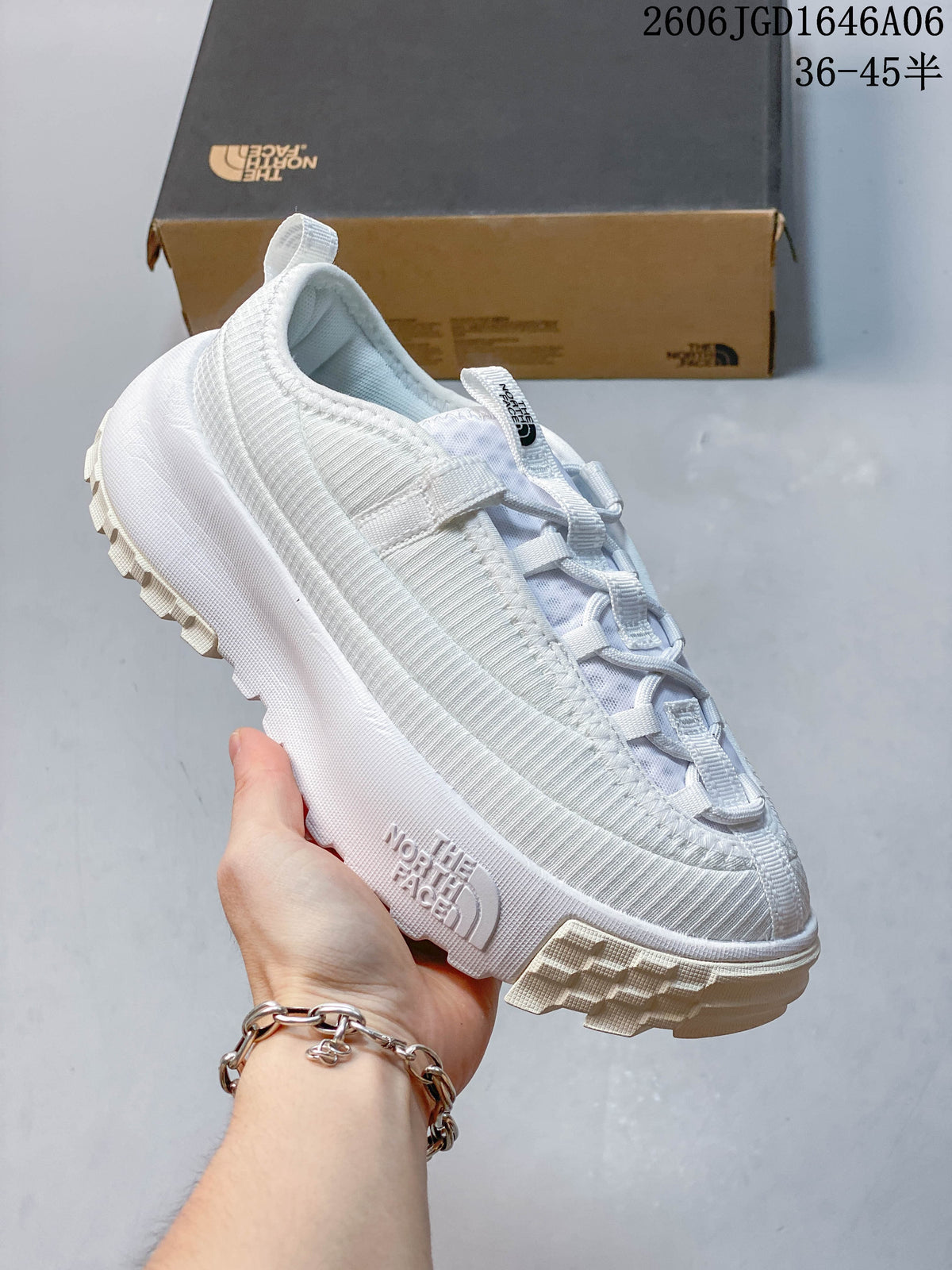 Angled side view of the white mule shoe with visible The North Face branding.