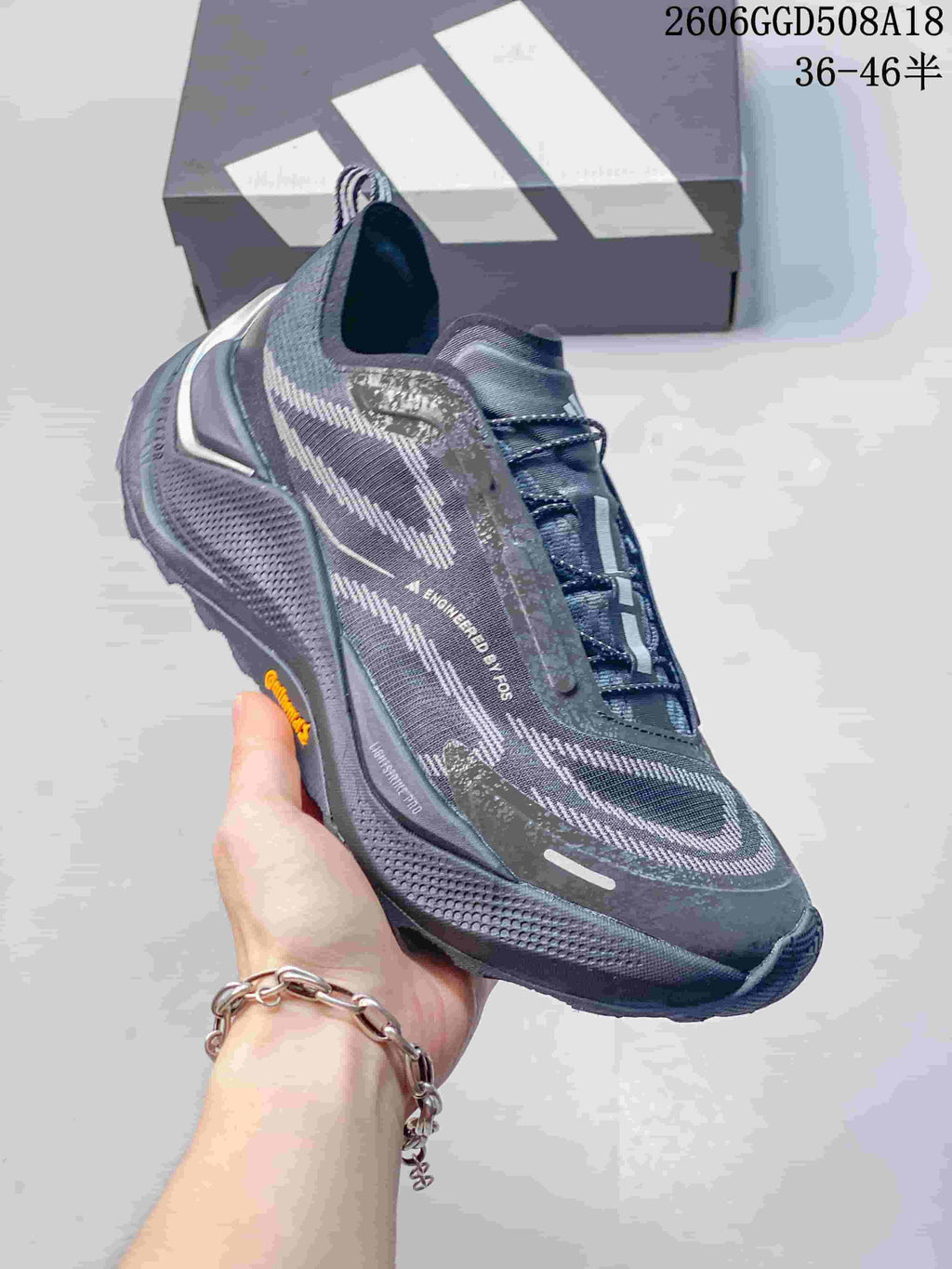 Side view highlighting the patterned upper and sole of a gray trail running shoe