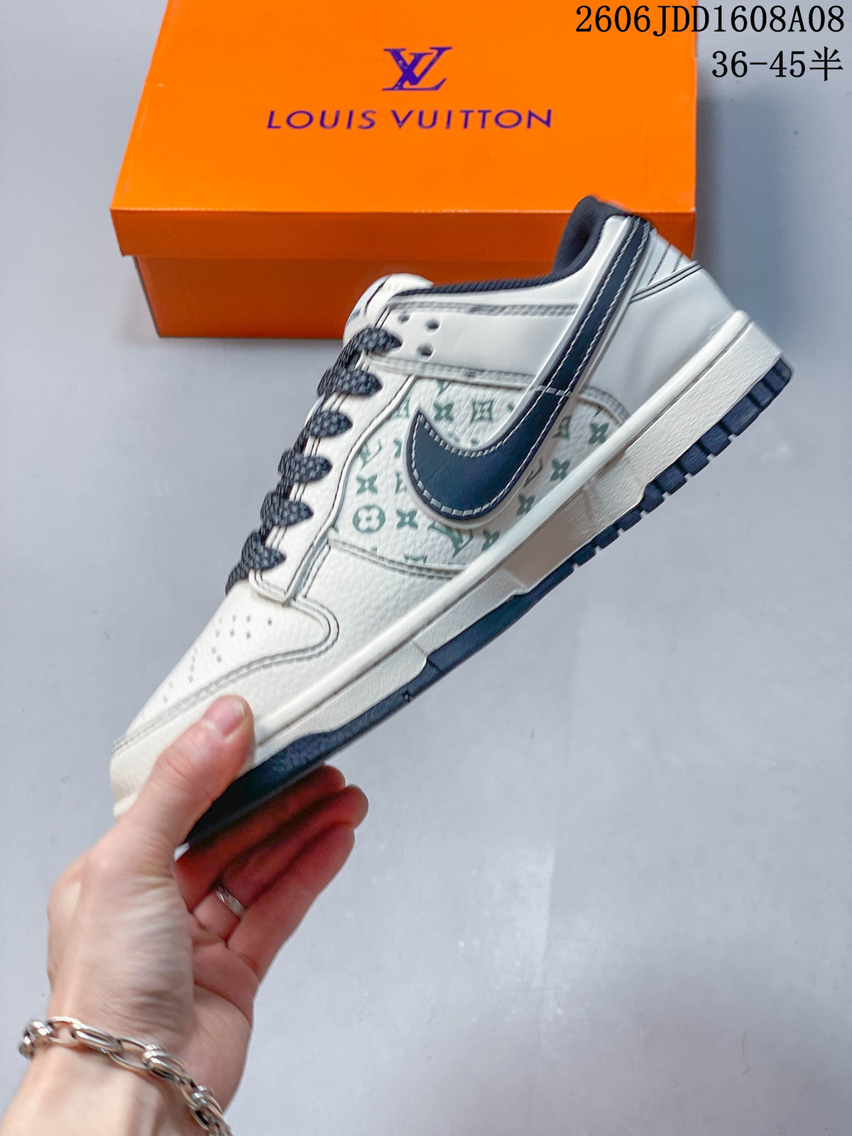 Side view of a cream low-top sneaker with patterned panels and a dark swoosh-shaped side detail