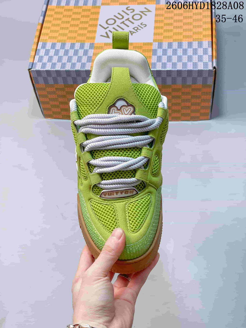 Front view of the sneaker with white laces and lime-green mesh panels