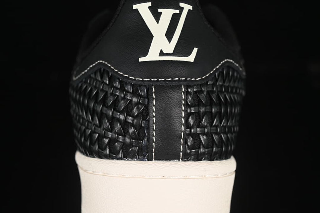 Heel close-up showing woven-look panels, contrast stitching and a logo