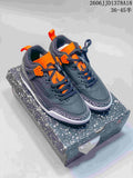 Pair of dark gray Jordan Spizike low-top sneakers with orange accents and elephant-print detailing, shown on a speckled shoebox.