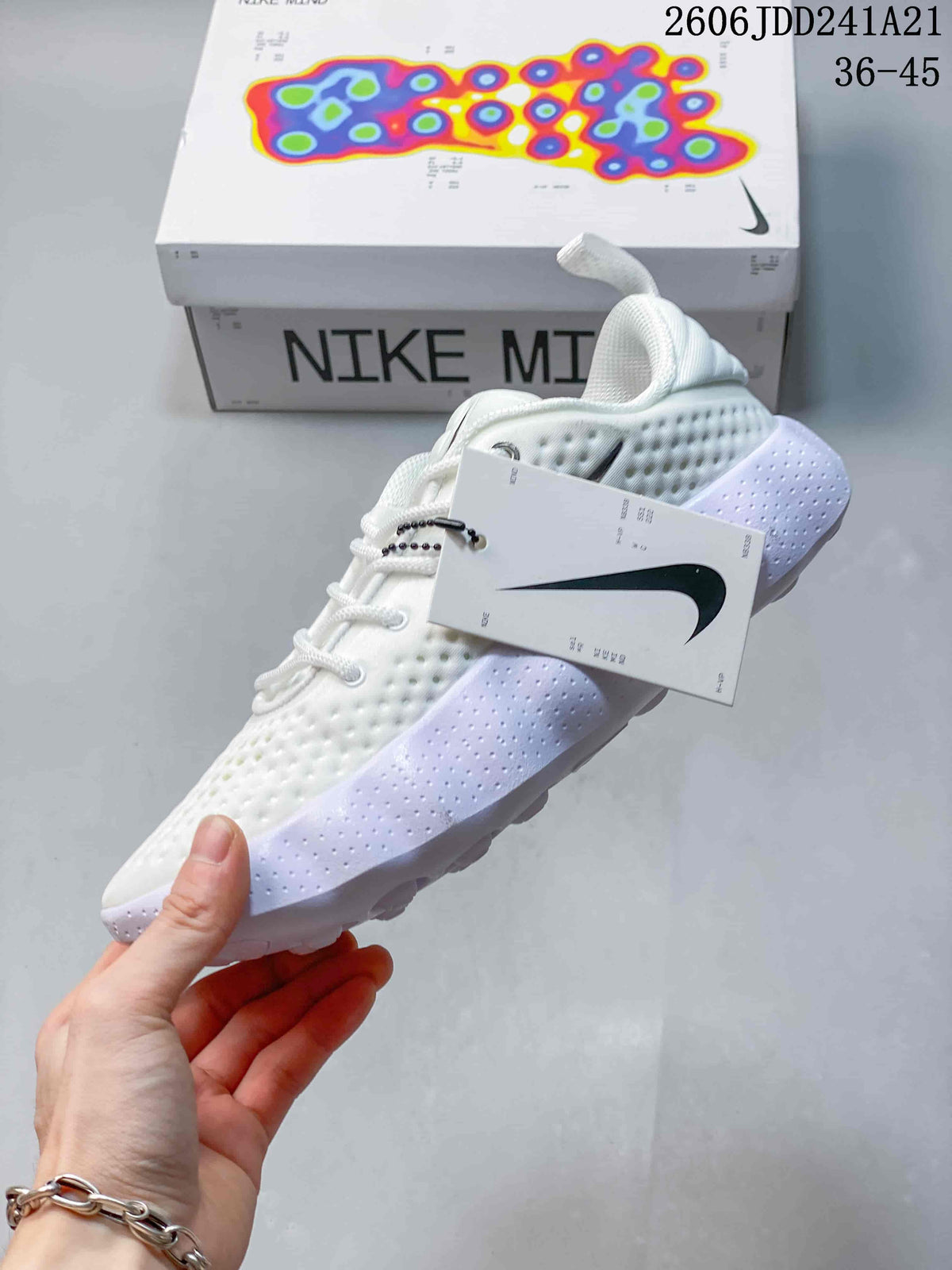 Side view of a white Nike Mind low-top shoe with pale lavender sole accents