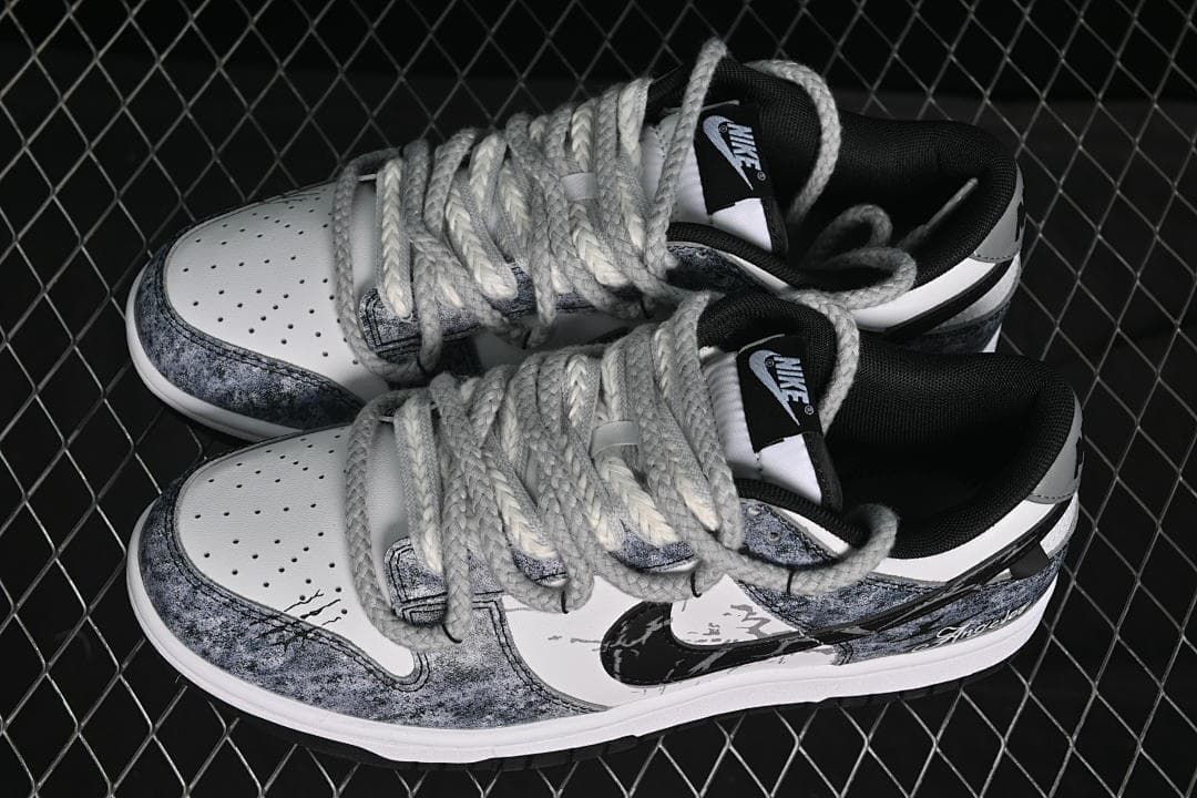 Top view of a pair of grey, black, and white Nike SB Dunk Low sneakers with thick grey laces